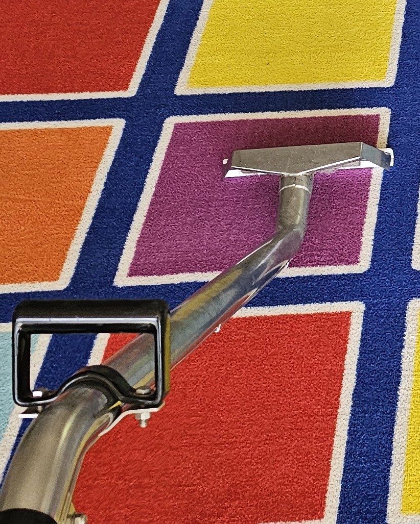 Our extraction wand working across a colourful classroom rug, rug cleaning done in place in Perth.