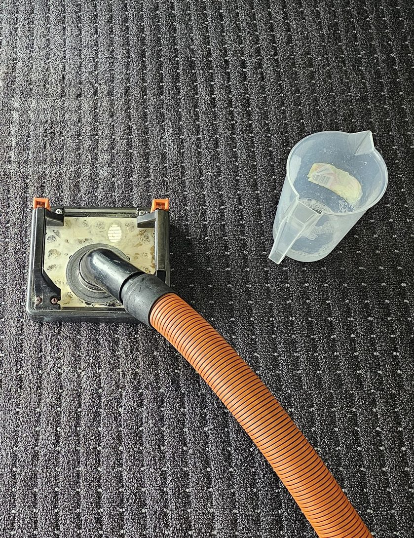 Our flood extraction tool drawing water out of office carpet tiles, water damage restoration in Perth.